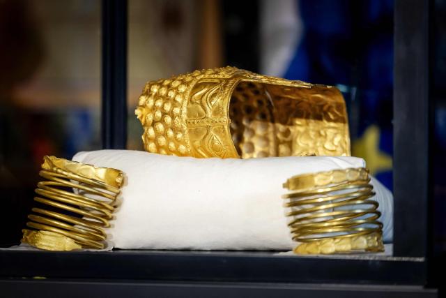 The recovered golden helmet of Cotofenesti and two gold bracelets that were stolen from the Drents Museum are displayed in a glass box in Assen on April 2, 2026. A priceless gold 2,500-year-old helmet from Romania that was stolen last year in the Netherlands has been recovered, Dutch art detective Arthur Brand told AFP on April 2, 2026. (Photo by Sem van der Wal / ANP / AFP) / Netherlands OUT
