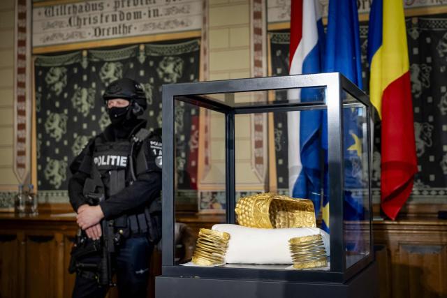 The recovered golden helmet of Cotofenesti and two gold bracelets that were stolen from the Drents Museum are displayed in a glass box in Assen on April 2, 2026. A priceless gold 2,500-year-old helmet from Romania that was stolen last year in the Netherlands has been recovered, Dutch art detective Arthur Brand told AFP on April 2, 2026. (Photo by Sem van der Wal / ANP / AFP) / Netherlands OUT