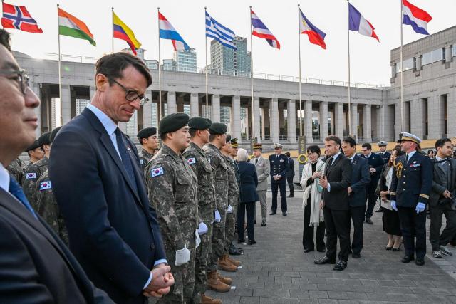 French President Emmanuel Macron (centre R) talks to South Korean military personnel during a visit to the War Memorial of Korea in Seoul on April 2, 2026. (Photo by Jeanne Accorsini / POOL / AFP)