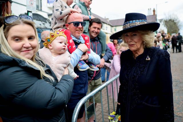 Britain's Queen Camilla meets a baby following a Royal Maundy Service at St Asaph Cathedral, in north Wales on April 2, 2026. (Photo by Chris Jackson / POOL / AFP)