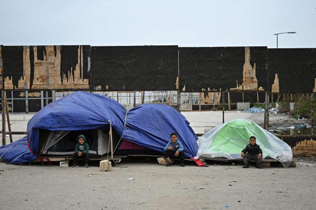 TOPSHOT - Displaced young children sit outside their tents at an unofficial camp for displaced people on Beirut's waterfront area on April 2, 2026. Lebanon was drawn into the Middle East war on March 2 when Tehran-backed militant group Hezbollah launched attacks on Israel to avenge the killing of the Iranian leader. Israel has responded with broad strikes across Lebanon and a ground offensive. (Photo by Joseph EID / AFP)