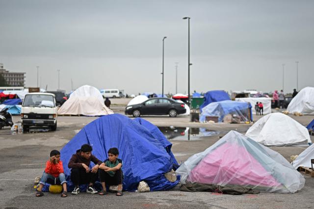 Displaced young boys sit at the entrance of a tent at an unofficial camp for displaced people on Beirut's waterfront area on April 2, 2026. Lebanon was drawn into the Middle East war on March 2 when Tehran-backed militant group Hezbollah launched attacks on Israel to avenge the killing of the Iranian leader. Israel has responded with broad strikes across Lebanon and a ground offensive. (Photo by Joseph EID / AFP)