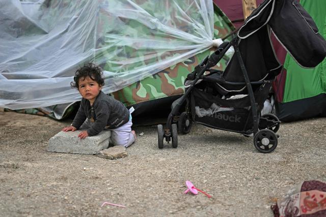 A displaced toddler crawls at the entrance of a tent at an unofficial camp for displaced people on Beirut's waterfront area on April 2, 2026. Lebanon was drawn into the Middle East war on March 2 when Tehran-backed militant group Hezbollah launched attacks on Israel to avenge the killing of the Iranian leader. Israel has responded with broad strikes across Lebanon and a ground offensive. (Photo by Joseph EID / AFP)