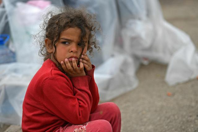 A displaced girl sits at the entrance of a tent at an unofficial camp for displaced people on Beirut's waterfront area on April 2, 2026. Lebanon was drawn into the Middle East war on March 2 when Tehran-backed militant group Hezbollah launched attacks on Israel to avenge the killing of the Iranian leader. Israel has responded with broad strikes across Lebanon and a ground offensive. (Photo by Joseph EID / AFP)