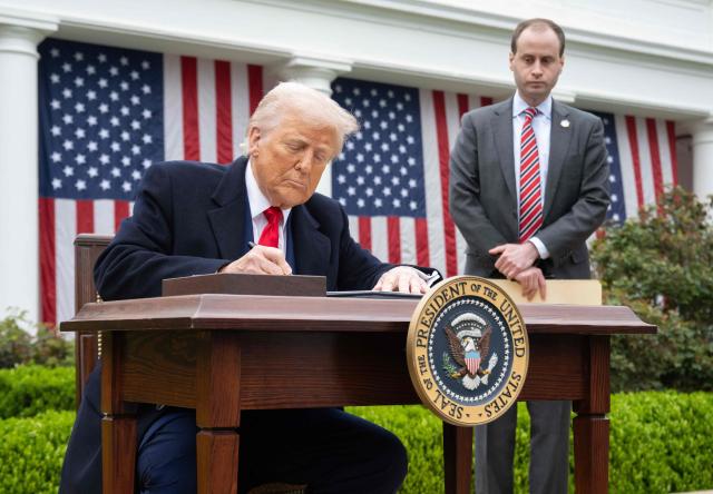 (FILES) US President Donald Trump signs an executive order after delivering remarks on reciprocal tariffs during an event in the Rose Garden entitled "Make America Wealthy Again" at the White House in Washington, DC, on April 2, 2025. The US trade deficit widened in Februart 2026 but less than analysts expected, government data showed on April 2, 2026, a year since President Donald Trump unleashed sweeping tariffs on virtually all trading partners. The overall gap expanded 4.9 percent to $57.3 billion as both imports and exports climbed, said the Commerce Department. Turmoil over Trump's tariff agenda, however, looks set to continue swaying trade flows in the world's biggest economy. (Photo by SAUL LOEB / AFP)