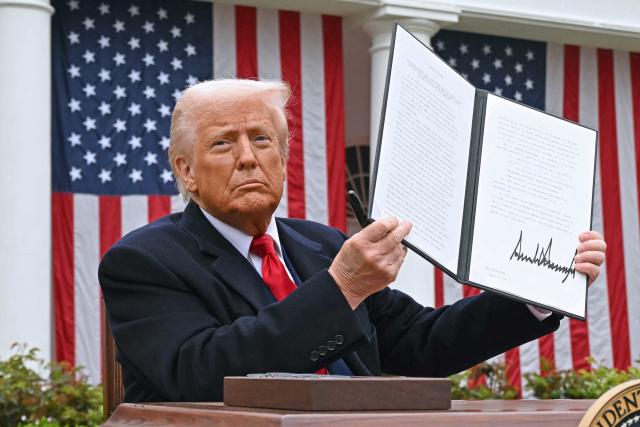 (FILES) US President Donald Trump holds a signed executive order after delivering remarks on reciprocal tariffs during an event in the Rose Garden entitled "Make America Wealthy Again" at the White House in Washington, DC, on April 2, 2025. The US trade deficit widened in Februart 2026 but less than analysts expected, government data showed on April 2, 2026, a year since President Donald Trump unleashed sweeping tariffs on virtually all trading partners. The overall gap expanded 4.9 percent to $57.3 billion as both imports and exports climbed, said the Commerce Department. Turmoil over Trump's tariff agenda, however, looks set to continue swaying trade flows in the world's biggest economy. (Photo by SAUL LOEB / AFP)