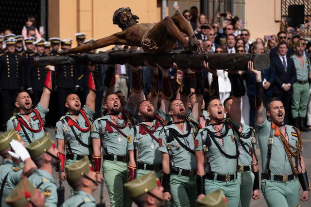 Members of the Spanish Legion carry a statue of the Christ of the Good Death to the Santo Domingo de Guzman church during a Holy Week procession in Malaga, southern Spain, on April 2, 2026. Spain's colourful Holy Week celebrations started this week, featuring centuries-old processions of the faithful carrying flower-covered floats topped with statues of Christ or the Virgin Mary that draw huge crowds. Organised by various religious brotherhoods, or "confradias", the parades are held across the country in the week leading up to Easter Sunday, which this year in the Roman Catholic Church falls on April 5, 2026. (Photo by JORGE GUERRERO / AFP)