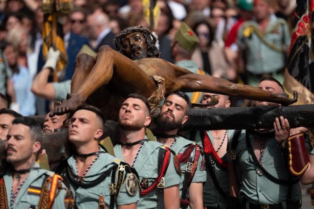 Members of the Spanish Legion carry a statue of the Christ of the Good Death to the Santo Domingo de Guzman church during a Holy Week procession in Malaga, southern Spain, on April 2, 2026. Spain's colourful Holy Week celebrations started this week, featuring centuries-old processions of the faithful carrying flower-covered floats topped with statues of Christ or the Virgin Mary that draw huge crowds. Organised by various religious brotherhoods, or "confradias", the parades are held across the country in the week leading up to Easter Sunday, which this year in the Roman Catholic Church falls on April 5, 2026. (Photo by JORGE GUERRERO / AFP)