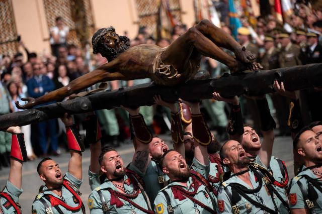 TOPSHOT - Members of the Spanish Legion carry a statue of the Christ of the Good Death to the Santo Domingo de Guzman church during a Holy Week procession in Malaga, southern Spain, on April 2, 2026. Spain's colourful Holy Week celebrations started this week, featuring centuries-old processions of the faithful carrying flower-covered floats topped with statues of Christ or the Virgin Mary that draw huge crowds. Organised by various religious brotherhoods, or "confradias", the parades are held across the country in the week leading up to Easter Sunday, which this year in the Roman Catholic Church falls on April 5, 2026. (Photo by JORGE GUERRERO / AFP)