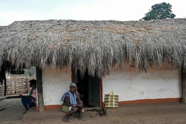 Villagers sit outside a hut in Mohandi village in Chhattisgarh on April 2, 2026. (Photo by Shammi MEHRA / AFP)