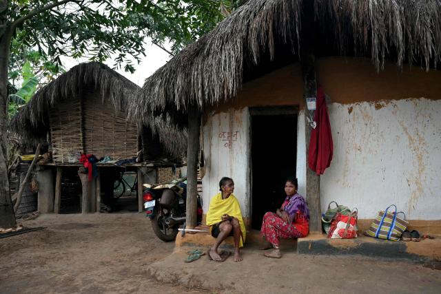 Women look on whilst they sit outside a hut in Mohandi village in Chhattisgarh on April 2, 2026. (Photo by Shammi MEHRA / AFP)
