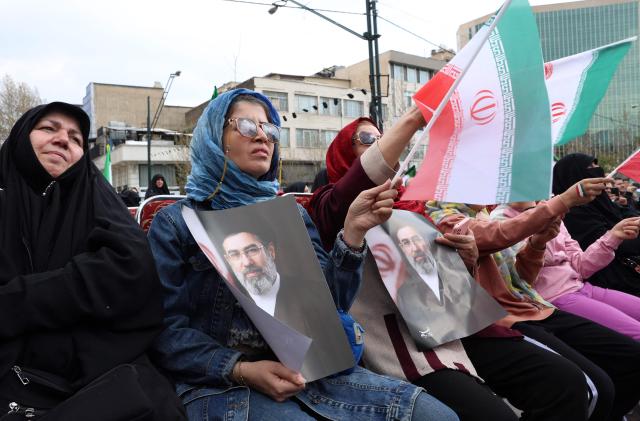 Iranian women hold portraits of Iran's supreme leader Mojtaba Khamenei while gathering in front of Tehran's Mellat park on April 2, 2026, during "Sizdeh Bedar" (Nature Day), the 13th day after the Nowruz Persian New Year, when people traditionally picnic outdoors with family and friends. Iran on April 2, threatened "crushing" attacks on the US and Israel, firing missiles at Tel Aviv after the US president vowed to bomb the Islamic republic "back to the Stone Ages". (Photo by AFP) / 