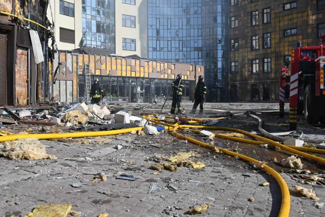 Ukrainian rescuers work in the courtyard of a damaged residential building following a drone attack in Kharkiv on April 2, 2026, amid the Russian invasion of Ukraine. (Photo by SERGEY BOBOK / AFP)