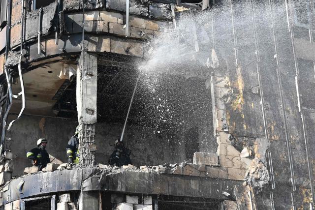 Ukrainian rescuers work to extinguish a fire in a damaged residential building following a drone attack in Kharkiv on April 2, 2026, amid the Russian invasion of Ukraine. (Photo by SERGEY BOBOK / AFP)