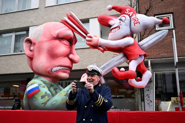 (FILES) German carnival float builder Jacques Tilly takes a picture as he poses for photographers in front of one his creation, a carnival float featuring Russian President Vladimir Putin, during the parade to celebrate Rose Monday (Rosenmontag), on February 16, 2026 in Duesseldorf, western Germany. According to German media, a Russian court has sentenced German sculptor Jacques Tilly to more than eight years in prison in absentia in a controversial trial in Moscow. Tilly, widely known for his sharply satirical carnival floats, responded to the verdict with mockery rather than concern. (Photo by INA FASSBENDER / AFP)