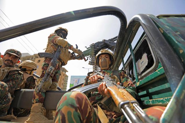 TOPSHOT - Yemeni security personnel keep vigil as supporters of Iran-backed Houthis, gather in Sanaa on April 2, 2026, during a protest against the Israeli parliament's approval of a new death penalty bill for Palestinians convicted of deadly attacks. The bill would make the death penalty the default punishment for Palestinians in the Israeli-occupied West Bank found guilty of intentionally carrying out deadly attacks deemed "acts of terrorism" by an Israeli military court. (Photo by Mohammed HUWAIS / AFP)
