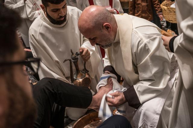 A Catholic Priest dries the foot of a member of the Palestinian Scouts during the Maundy Thursday’s Washing of the Feet ceremony at the Christ the Saviour Church in the old city of Jerusalem, on April 2, 2026. Holy sites in Jerusalem's old city have remained closed for security reasons since the outbreak of the Middle East war on February 28, when Israel and the US launched strikes on Iran. (Photo by MARCO LONGARI / AFP)