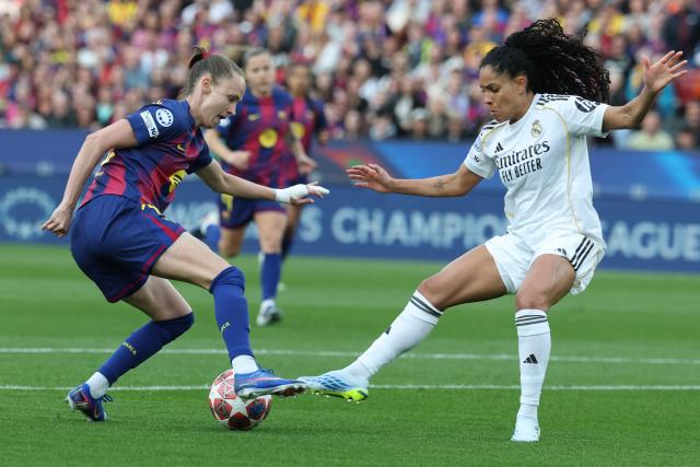 Barcelona's Norwegian forward #10 Caroline Graham Hansen (L) vies for the ball with Real Madrid's Brazilian defender #12 Yasmim during the UEFA Women's Champions League quarter final second leg football match between FC Barcelona and Real Madrid CF at the Camp Nou stadium in Barcelona on April 2, 2026. (Photo by Lluis GENE / AFP)