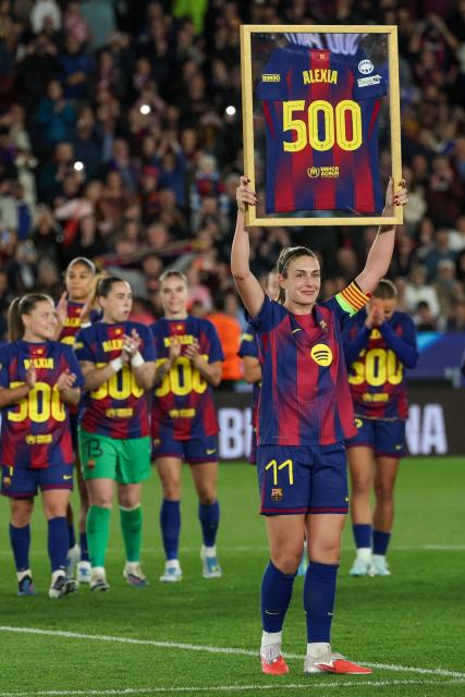 Barcelona's Spanish midfielder #11 Alexia Putellas holds up a jersey to celebrate her 500th appearance with Barcelona after the UEFA Women's Champions League quarter final second leg football match between FC Barcelona and Real Madrid CF at the Camp Nou stadium in Barcelona on April 2, 2026. (Photo by Lluis GENE / AFP)