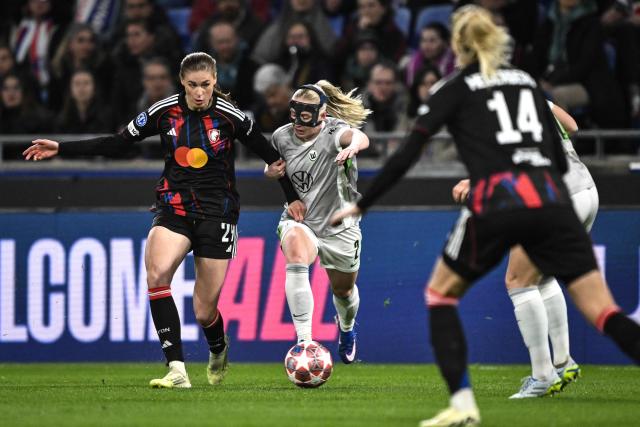 Lyon's German midfielder #29 Jule Brand (L) fights for the ball with VfL Wolfsburg's Norwegian defender #02 Thea Bjelde (C) during the UEFA Women's Champions League quarter final second leg football match between OL Lyonnes (Lyon) and VfL Wolfsburg at the Groupama stadium in Decines-Charpieu, central-eastern France, on April 2, 2026. (Photo by JEFF PACHOUD / AFP)