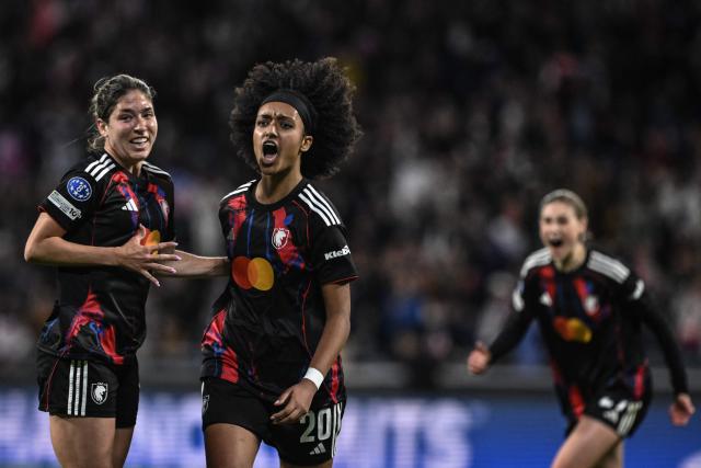 Lyon's US midfielder #20 Lily Yohannes (C) celebrates with teammates after scoring her team's first goal during the UEFA Women's Champions League quarter final second leg football match between OL Lyonnes (Lyon) and VfL Wolfsburg at the Groupama stadium in Decines-Charpieu, central-eastern France, on April 2, 2026. (Photo by JEFF PACHOUD / AFP)
