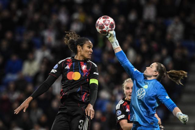 VfL Wolfsburg's German goalkeeper #01 Stina Johannes (R) clears the ball in front of Lyon's French defender #03 Wendie Renard (L) during the UEFA Women's Champions League quarter final second leg football match between OL Lyonnes (Lyon) and VfL Wolfsburg at the Groupama stadium in Decines-Charpieu, central-eastern France, on April 2, 2026. (Photo by JEFF PACHOUD / AFP)