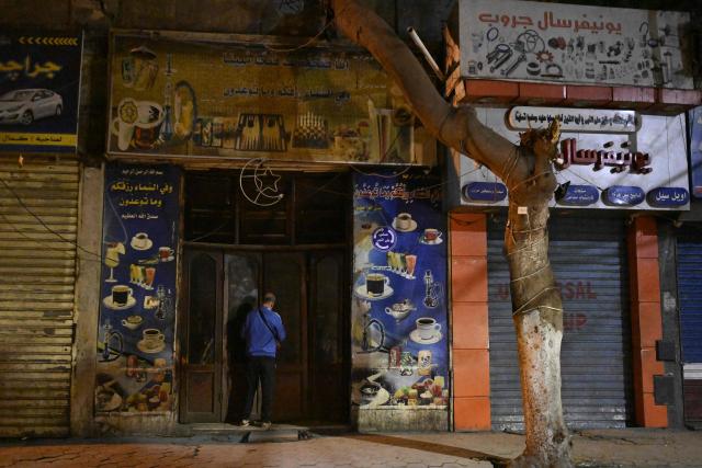 A shop owner closes his shop closing in downtown Cairo on April 2, 2026. Egypt has ordered shops, restaurants and shopping malls to close from 9:00 pm from April 3, hoping to curb energy bills that have more than doubled because of the Iran war. Prime Minister Mostafa Madbouly announced the curfew and said it would last for a month initially. (Photo by Khaled DESOUKI / AFP)