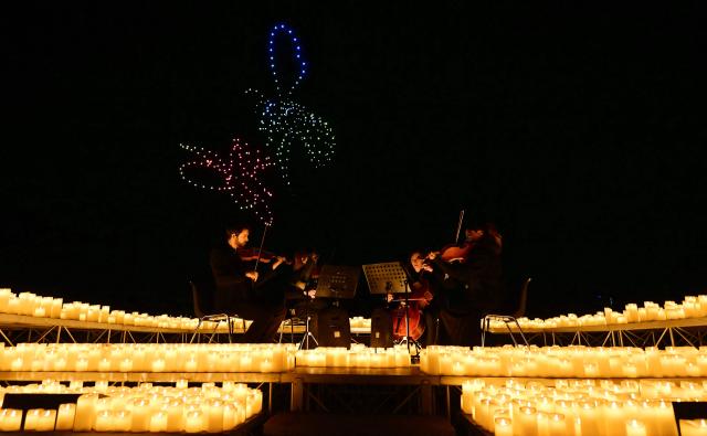 A string quartet performs as over 1,000 drones form a figure in the sky during the DroneArt show in Milan, on April 2, 2026. (Photo by Stefano RELLANDINI / AFP)