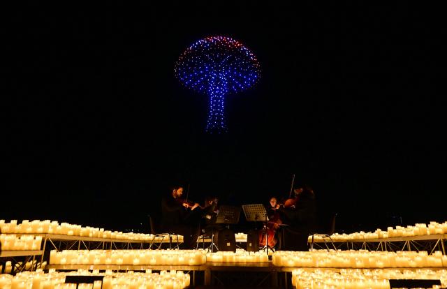 A string quartet performs as over 1,000 drones form a figure in the sky during the DroneArt show in Milan, on April 2, 2026. (Photo by Stefano RELLANDINI / AFP)
