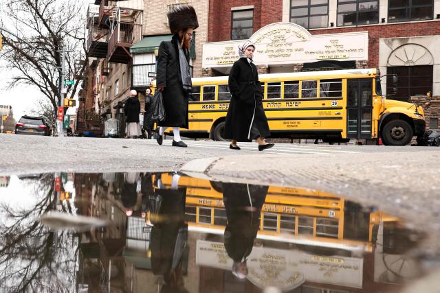 An Ultra-Orthodox Jewish couple walks in a street of Williamsburg in the Brooklyn borough of New York during Passover (Pesach) on April 2, 2026. Pesach, which runs from April 1-9 this year, is a major eight-day Jewish holiday commemorating the biblical Exodus of the Israelites from Egyptian slavery. (Photo by CHARLY TRIBALLEAU / AFP)