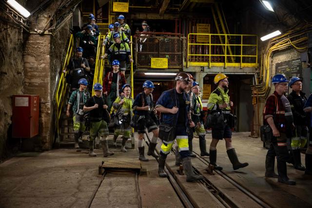 Miners walk down together for their shift more than 1,000 meters underground at the Polkowice–Sieroszowice copper and silver mine in southwestern Poland, owned by KGHM - the metallurgical giant in the country, on March 25, 2026. Thousands of meters beneath the ground, amid suffocating heat, lies one of the keys to Poland's rumbling mining sector -- and the world economy. (Photo by Wojtek RADWANSKI / AFP)