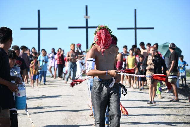 Penitents flagellate themselves as they walk to a mound with crosses prior to the annual crucifixion during the observance of Lent in the village of Cutud in San Fernando City, Pampanga province on April 3, 2026. (Photo by Ted ALJIBE / AFP)