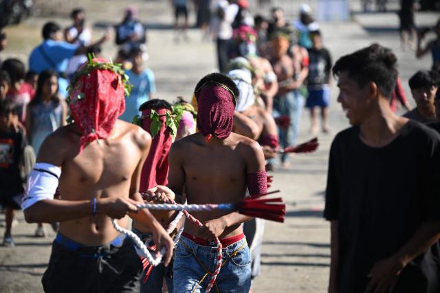Penitents flagellate themselves as they walk to a mound with crosses prior to the annual crucifixion during the observance of Lent in the village of Cutud in San Fernando City, Pampanga province on April 3, 2026. (Photo by Ted ALJIBE / AFP)