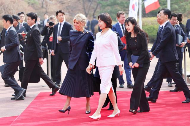French first lady Brigitte Macron (center-L) and South Korean first lady Kim Hea Kyung (center-R) attend the official welcome ceremony at the Blue House in Seoul on April 3, 2026. (Photo by Ludovic MARIN / AFP)