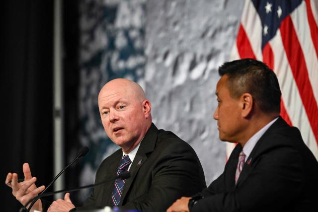 NASA Orion program manager Howard Hu (R) listens to NASA flight director Judd Frieling (L) speak during a status briefing of the Artemis II crewed lunar mission at Johnson Space Center in Houston, Texas, on April 2, 2026. On April 2, the four Artemis astronauts fired up their spacecraft's engine to break away from Earth's orbit and zoomed towards the Moon, a milestone that commits NASA to the first crewed lunar flyby in more than half-a-century. The 10-day Artemis 2 mission is aimed at paving the way for a Moon landing in 2028. (Photo by RONALDO SCHEMIDT / AFP)