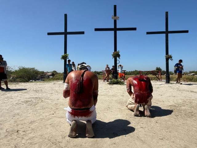 Penitents with bloodied back due to flagellation kneel in front of crosses prior to the annual crucifixion in the village of Cutud, San Fernando town, Pampanga province, north of Manila on April 3, 2026. (Photo by TED ALJIBE / AFP)