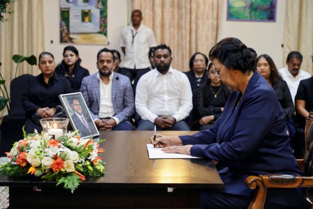TOPSHOT - Suriname's President Jennifer Simons-Geerlings signs a condolence register for late former president Chandrikapersad Santokhi at the presidential palace in Paramaribo on April 2, 2026. Former Surinamese President Chan Santokhi, known for his investigation into the 1982 massacre of opposition members during the dictatorship of Desi Bouterse, has died at the age of 67, the government announced on March 30, 2026. Santokhi served as president of Suriname from 2020 to 2025, when he handed over power to opposition leader Jennifer Geerlings-Simons. (Photo by Ranu ABHELAKH / AFP)