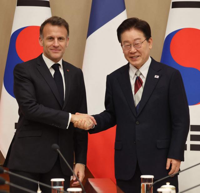 French President Emmanuel Macron (L) shakes hands with South Korean President Lee Jae Myung before their bilateral meeting in Seoul on April 3, 2026. (Photo by Ludovic MARIN / AFP)