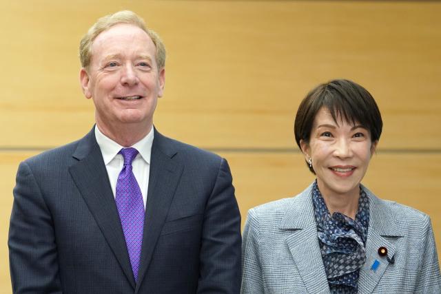 Microsoft's Vice Chair and President Brad Smith (L) and Japan’s Prime Minister Sanae Takaichi pose before their meeting at the Prime Minister’s Office in Tokyo on April 3, 2026. (Photo by Kazuhiro NOGI / POOL / AFP)