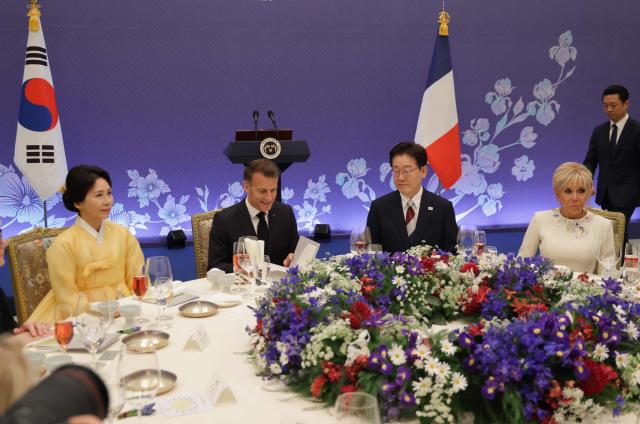 French President Emmanuel Macron (2nd-L), South Korean President Lee Jae-myung (2nd-R), First Lady Brigitte Macron (R) and First Lady Kim Hea Kyung attend a state lunch in Seoul on April 3, 2026. (Photo by Ludovic MARIN / AFP)