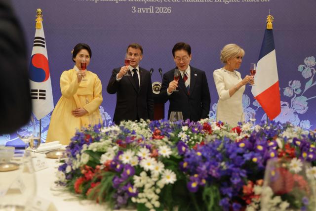 French President Emmanuel Macron (2nd-L), South Korean President Lee Jae-myung (3nd-R), First Lady Brigitte Macron (R) and First Lady Kim Hea Kyung toasts during a state lunch in Seoul on April 3, 2026. (Photo by Ludovic MARIN / AFP)