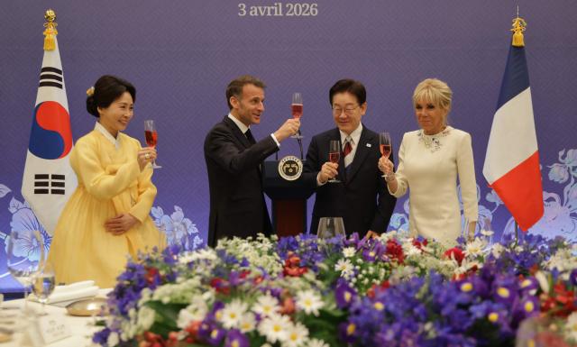 French President Emmanuel Macron (2nd-L), South Korean President Lee Jae-myung (3nd-R), First Lady Brigitte Macron (R) and First Lady Kim Hea Kyung toasts during a state lunch in Seoul on April 3, 2026. (Photo by Ludovic MARIN / AFP)