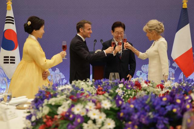 French President Emmanuel Macron (2nd-L), South Korean President Lee Jae-myung (3nd-R), First Lady Brigitte Macron (R) and First Lady Kim Hea Kyung toasts during a state lunch in Seoul on April 3, 2026. (Photo by Ludovic MARIN / AFP)