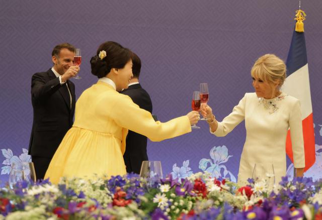 French First Lady Brigitte Macron (R) and South Korean First Lady Kim Hea Kyung toast as President Emmanuel Macron (L) looks on during a state lunch in Seoul on April 3, 2026. (Photo by Ludovic MARIN / AFP)