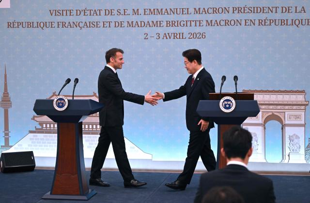 French President Emmanuel Macron (L) shakes hands with South Korean President Lee Jae Myung (R) during a joint press conference after their meeting at the presidential Blue House in Seoul on April 3, 2026. (Photo by JUNG YEON-JE / POOL / AFP)
