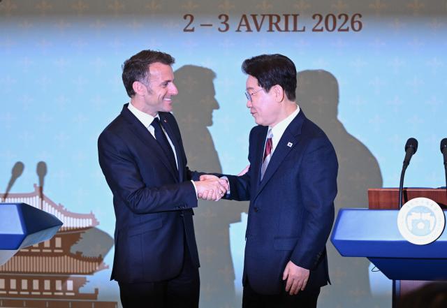 French President Emmanuel Macron (L) shakes hands with South Korean President Lee Jae Myung (R) during a joint press conference after their meeting at the presidential Blue House in Seoul on April 3, 2026. (Photo by JUNG YEON-JE / POOL / AFP)