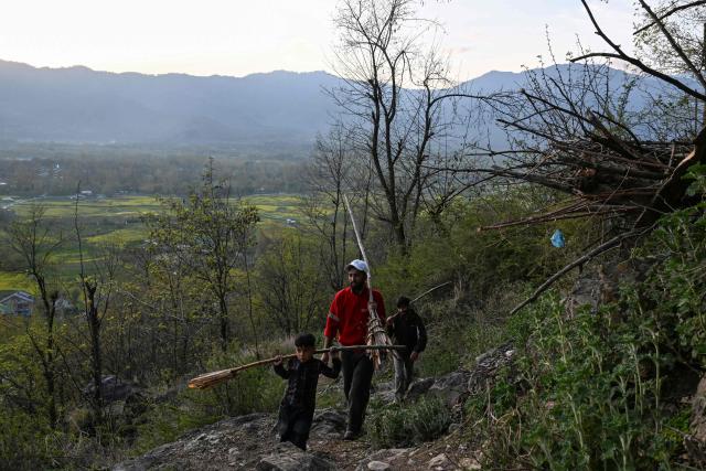 Kashmiri Muslims carry torches to be lit during the annual Aishmuqaam festival to mark the end of winter and the beginning of the sowing season at the shrine of Sufi saint Zain-ud-din Wali in Anantnag, south of Srinagar on April 2, 2026. (Photo by Tauseef MUSTAFA / AFP)