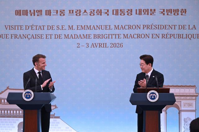French President Emmanuel Macron (L) and South Korean President Lee Jae Myung (R) react during a joint press conference after their meeting at the presidential Blue House in Seoul on April 3, 2026. (Photo by JUNG YEON-JE / POOL / AFP)