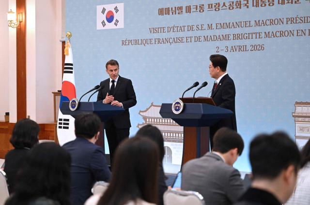 French President Emmanuel Macron (L) speaks as South Korean President Lee Jae Myung (R) listens to during a joint press conference after their meeting at the presidential Blue House in Seoul on April 3, 2026. (Photo by JUNG YEON-JE / POOL / AFP)