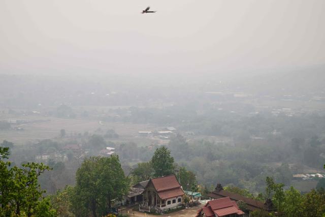 A general view shows a bird in flight on a heavily polluted day in Pai on April 1, 2026, west of Thailand's second-largest city Chiang Mai. Seasonal agricultural burning, forest fires and weather patterns produce an annual pollution season across much of Southeast Asia. But parts of northern Thailand are seeing haze that even hardened locals say is exceptional. (Photo by ANTHONY WALLACE / AFP) / To go with 'Thailand-Pollution-Environment-Fire-Health' Reportage by Chayanit ITTHIPONGMAETEE